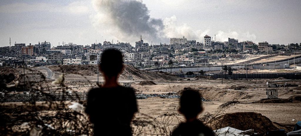 septiembre © UNICEF Dos ninos observan columnas de humo tras un ataque aereo sobre la ciudad de Gaza.